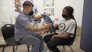 nurse checking studentʻs blood pressure