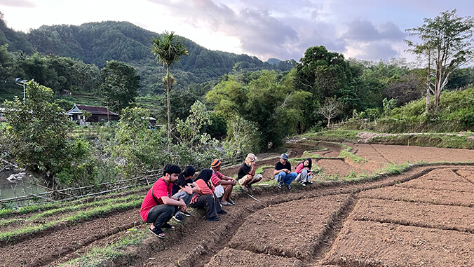 people squatting in peanut farm plot