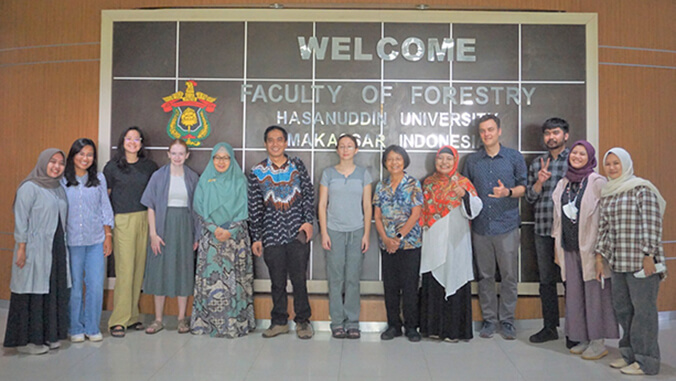 students in front of sign that says welcome faculty of forestry hasanuddin university makassar indonesia