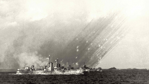 Black and white image of bombs dropping on a ship at sea