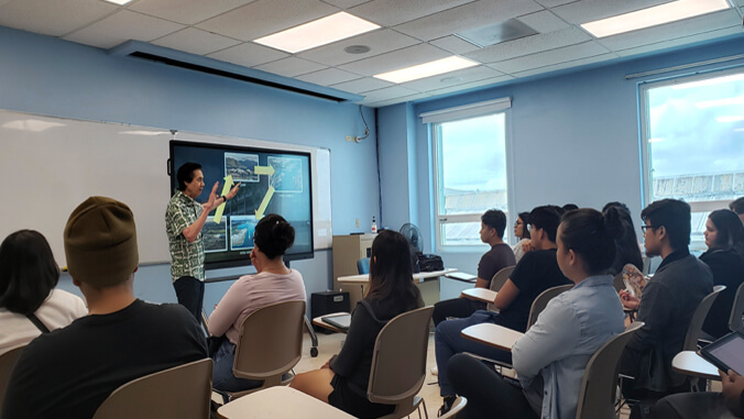 person talking to a group of people in a classroom