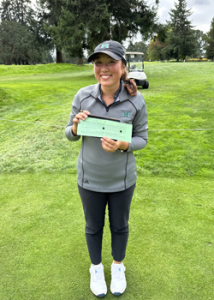 person standing with a gray shirt and a scorecard