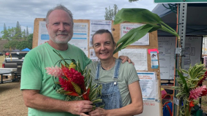 two people holding a bouquet of plants