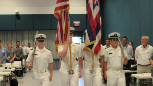 people in uniforms carrying flags