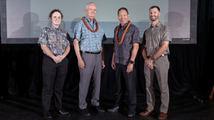 four people standing on a stage
