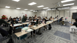 people in a room sitting on chairs and desks