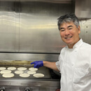 Chef Roy Yamaguchi flipping Pōʻalua Pancakes at Kapiʻolani CC