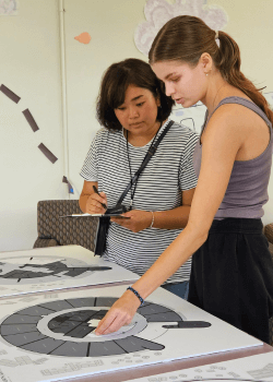 student moving paper furniture on floor map of aloha tower