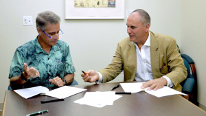 two men signing papers