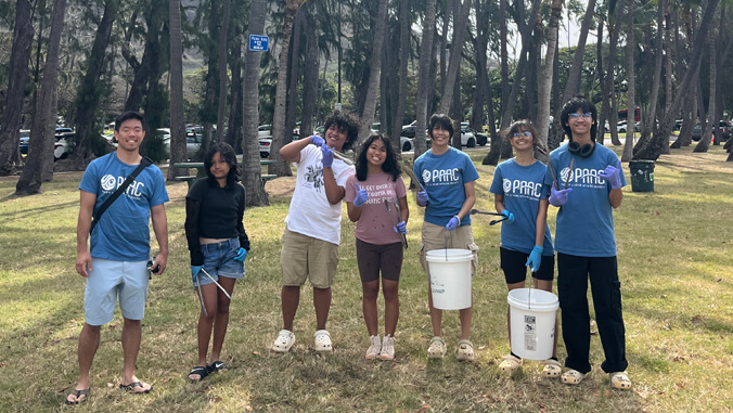 People smiling with buckets ready to clean up
