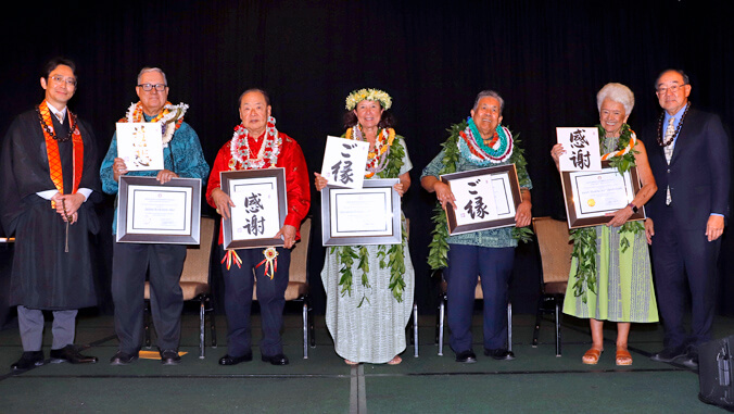 7 people on stage, 5 holding award