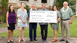 six people holding a check