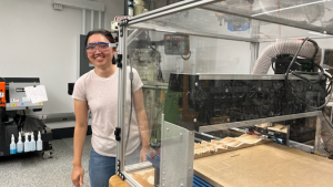 person smiling in a lab with machines