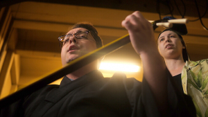 Student playing shamisen in front of another student