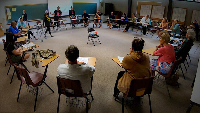 participants sitting at desks in a circle.