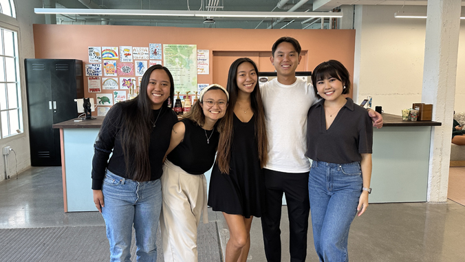 five people smiling in a shop