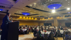 people sitting on tables in a large ballroom