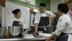 Three people prepping in the kitchen