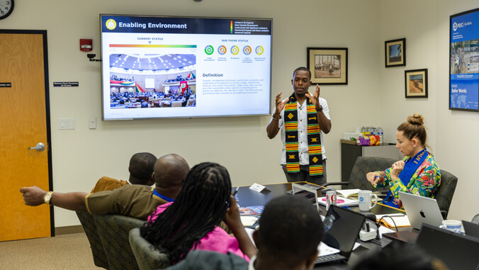 a person presenting in front of a conference room