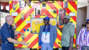 4 people in front of a firefighter truck.