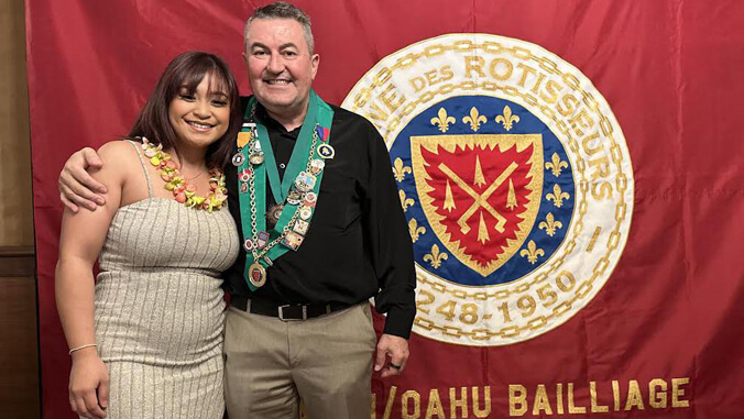 Two people standing in front of a banner