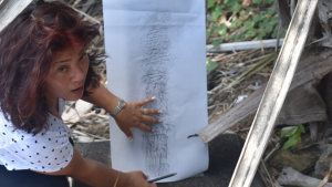 woman holding paper and pencil on a gravestone