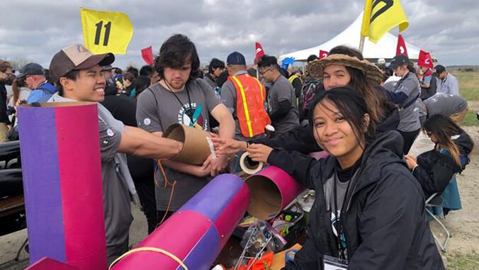 Students preparing their rocket outside