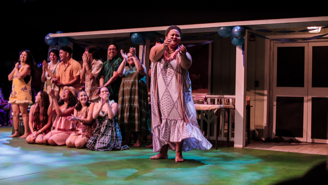 ensemble watching a hula dancer.