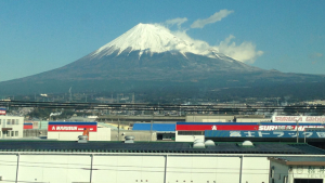large snow capped mountain behind a city