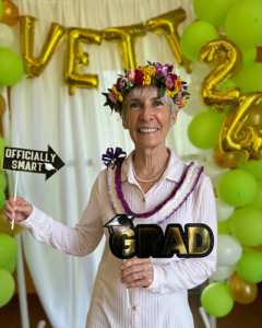 Pagotto holding photo booth props in front of balloons that say vett 24