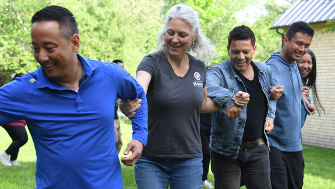 People with linked arms dancing