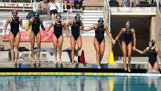 U H women swimmers jumping into pool
