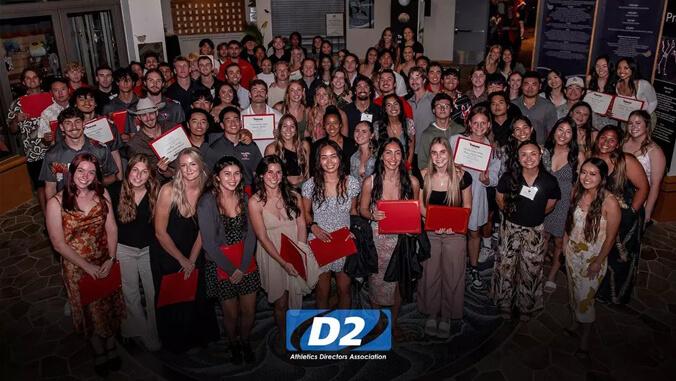 a group photo of student-athletes holding their award
