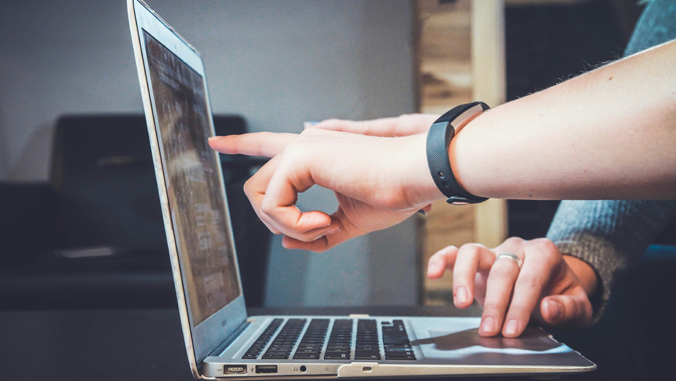 person pointing to a laptop