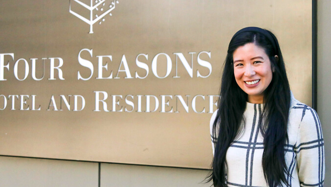 Kelly Valdezj standing in front of Four Seasons sign