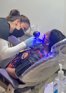 person helping check a patient's teeth