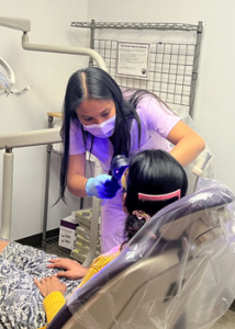 person helping check a patient's teeth