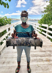 person holding up a large basket of oysters