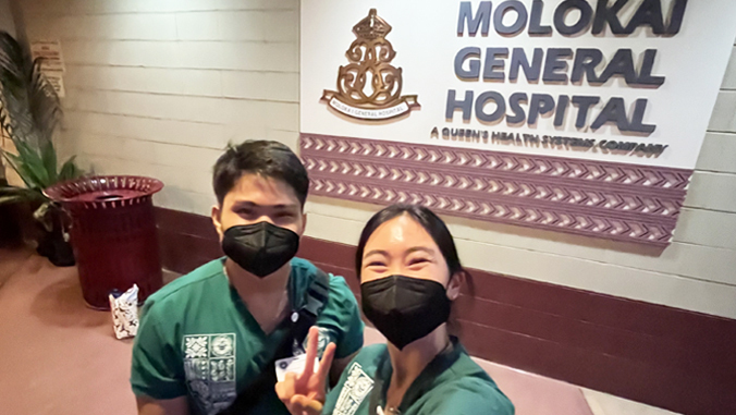 abad and xiao in front of molokai hospital sign