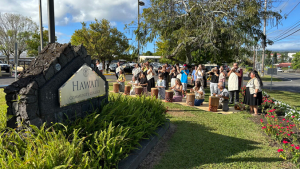 Hawaii C C sign and people performing Kipaepae
