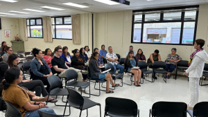 Hensel addresses a room of people