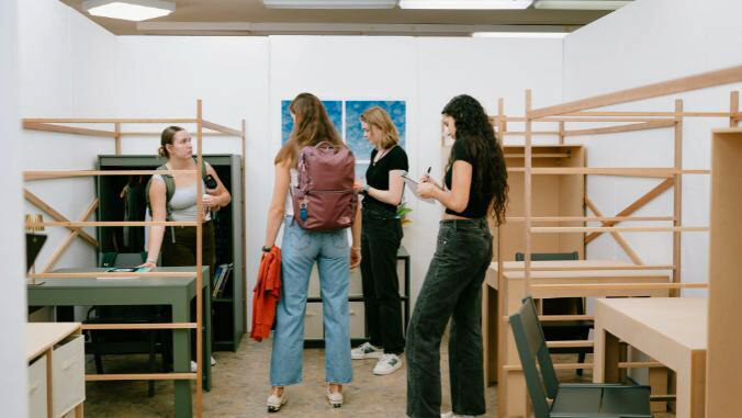 4 students looking at room mock-up