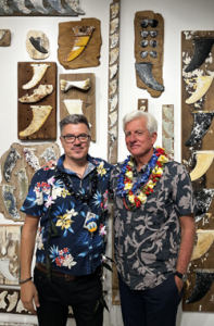 Two people in front of a wall of art pieces