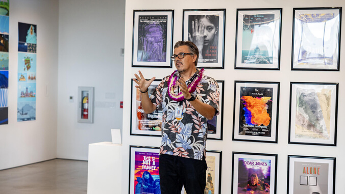 Person standing in front of framed art pieces