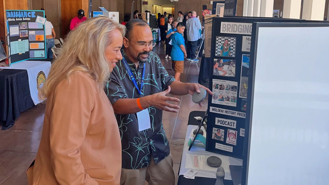 two people looking at a poster board