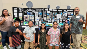 people smiling in front of a poster board