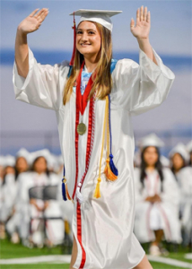 person in a cap and gown waving