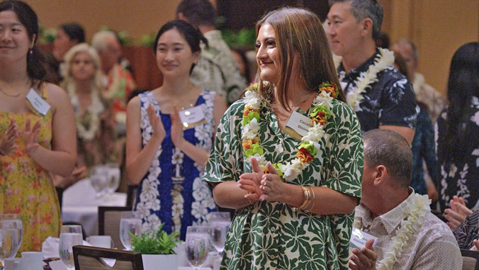 person with a lei standing and smiling