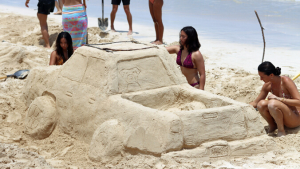 people sculpting sand on a beach