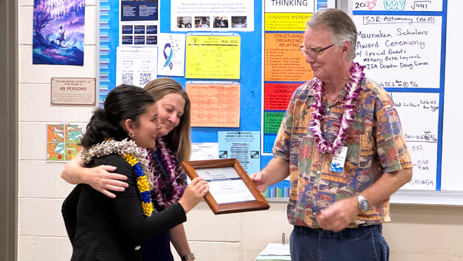 a man and woman presenting a certificate to a student